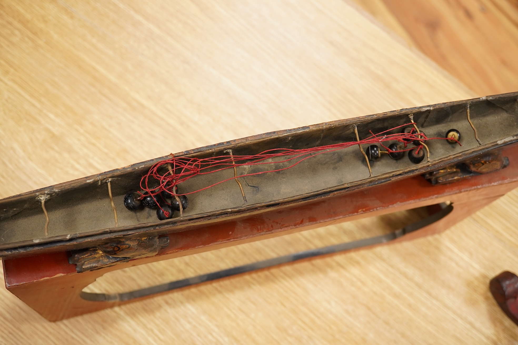 A South East Asian gilt decorated black lacquer model 'dragon' boat on stand, 75cm